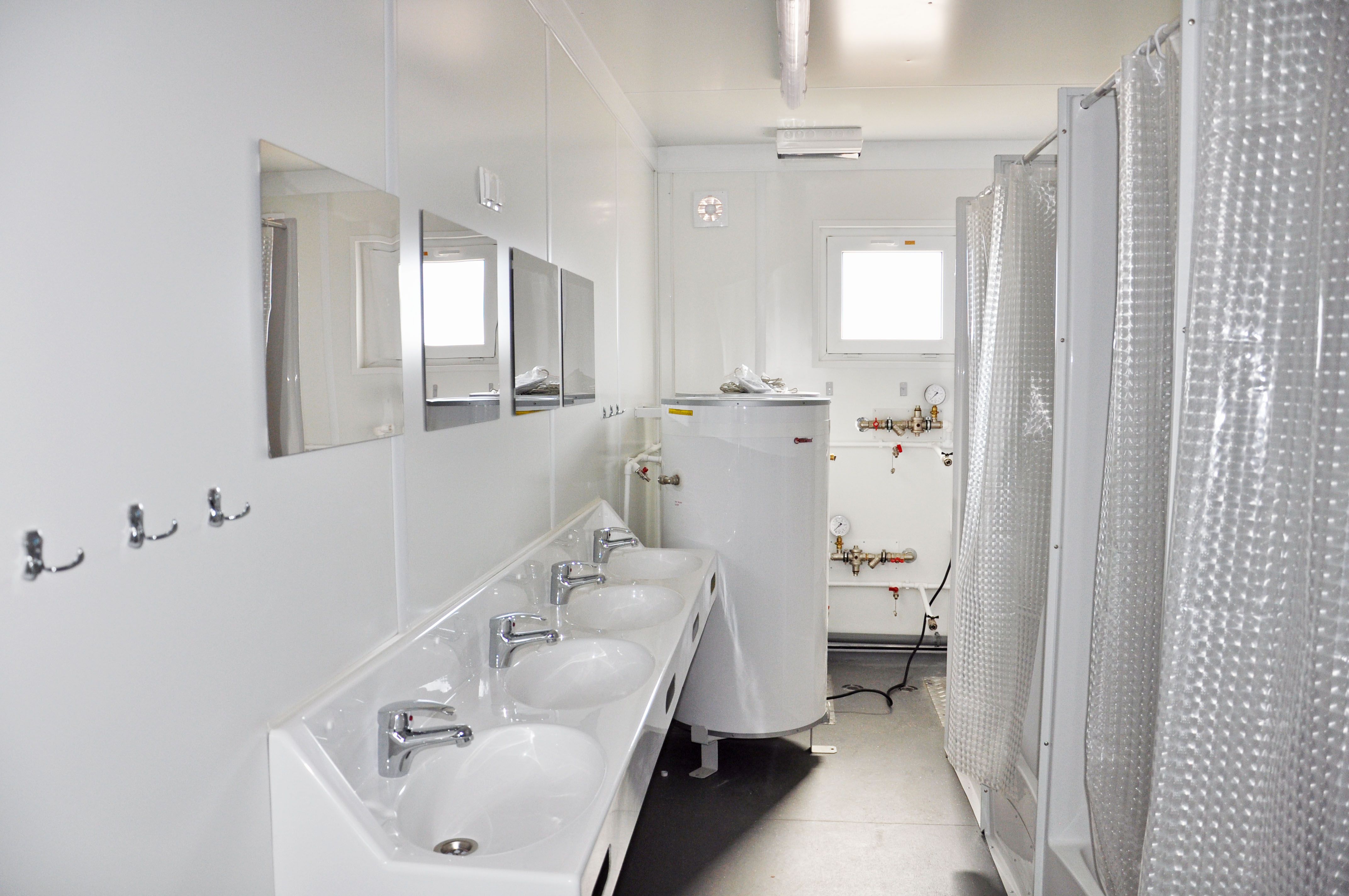 Prefabbricato modulare ad uso sanitario con lavabo e cabine doccia